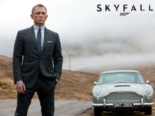 Daniel Craig standing on a road with silver car in the background. Skyfall poster from Amazon.com.